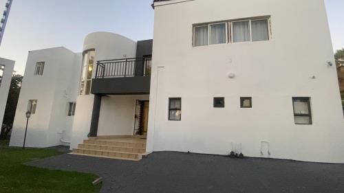 a white building with a staircase on the side of it at Siena Sun Guesthouse Rooms and Breakfast Option in Midrand