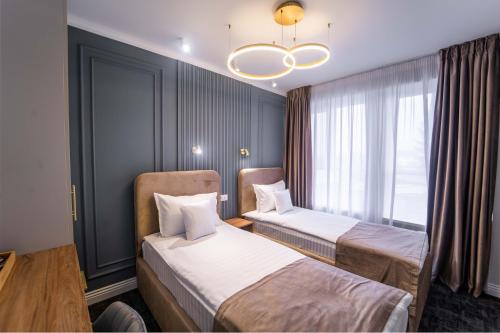 a hotel room with two beds and a chandelier at Hotel Zamca Suceava in Suceava