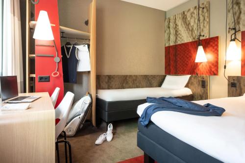 a hotel room with two beds and a desk at ibis Genève Centre Gare in Geneva