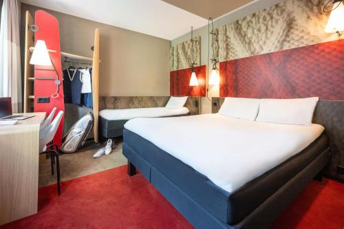 a hotel room with a large bed and a desk at ibis Genève Centre Gare in Geneva
