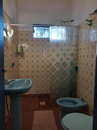 uma casa de banho com um WC, um lavatório e um chuveiro em Casa colonial a metros del arroyo Piribebuy em Piribebuy