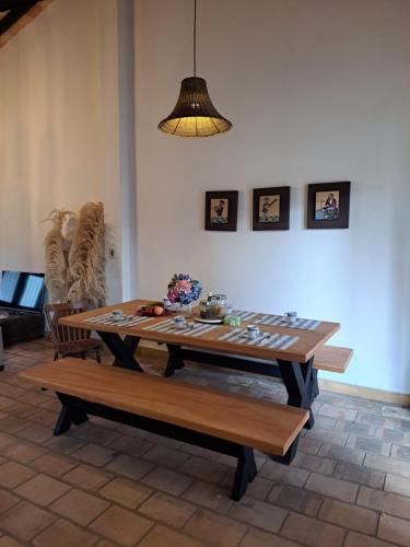 a table and benches in a living room with a lamp at Casa colonial a metros del arroyo Piribebuy in Piribebuy
