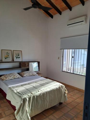 a bedroom with a bed in a room with a window at Casa colonial a metros del arroyo Piribebuy in Piribebuy