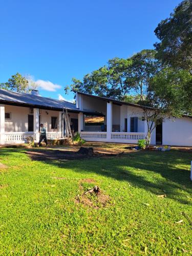 a white house with a yard in front of it at Casa colonial a metros del arroyo Piribebuy in Piribebuy