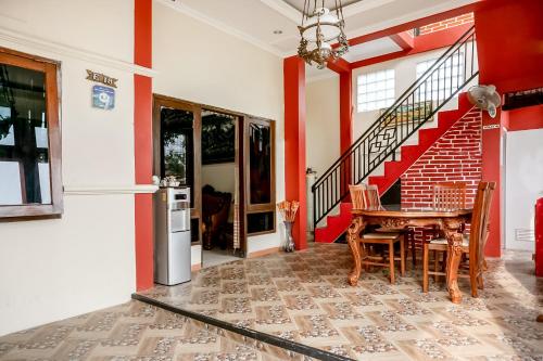 a dining room with a table and a staircase at The Homey Rooms and Tours in Yogyakarta