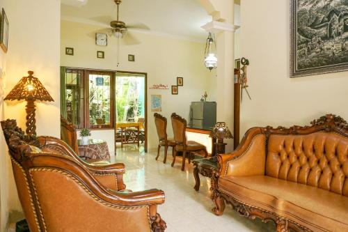 een woonkamer met banken en een tafel en stoelen bij The Homey Rooms and Tours in Yogyakarta