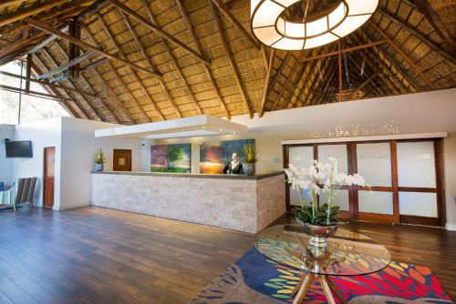 a lobby of a resort with a table and a bar at Seasons Golf, Leisure, Spa in Hartbeespoort