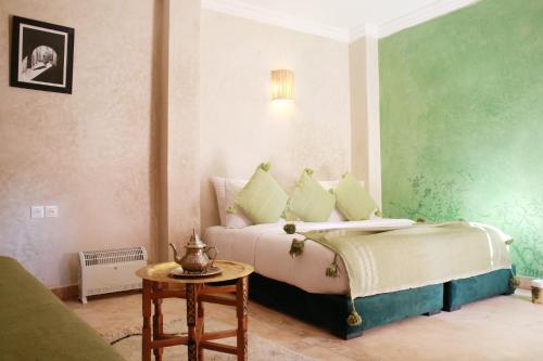 a bedroom with a bed and a table at Riad Dar Sirine in Marrakech