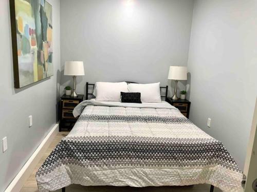 ein Bett in einem Schlafzimmer mit zwei Nachttischen und zwei Lampen in der Unterkunft Guesthouse near Disney, Walmart with private parking in Santa Ana