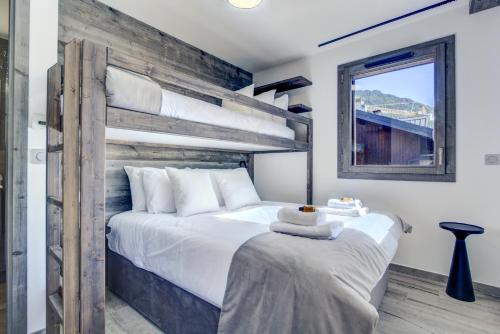 une chambre avec un lit superposé et une table dans l'établissement ECHO DU PLENEY B203: Incroyable 4 chambres neuf à 150m de la télécabine de Super-Morzine, à Morzine