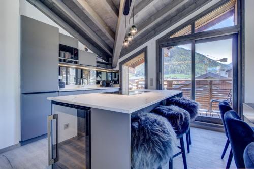 une cuisine avec un grand îlot et des tabourets dans l'établissement ECHO DU PLENEY B203: Incroyable 4 chambres neuf à 150m de la télécabine de Super-Morzine, à Morzine