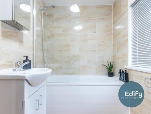 a bathroom with a bath tub and a sink at Spacious House Ideal For Groups in Southampton