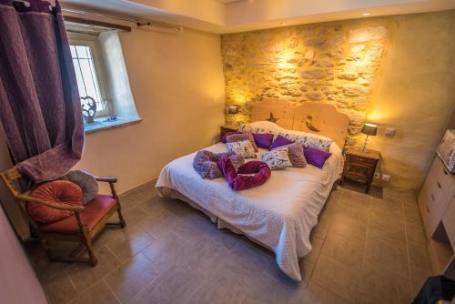 une chambre avec un lit et un mur en pierre dans l'établissement Gîte avec jacuzzi privatif dans un mas provençal, à Les Fumades-Les Bains