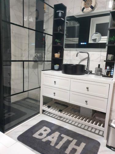 une salle de bain avec un lavabo et un miroir dans l'établissement Accueil familial & convivial - chambre privée chez l'habitant, à Agen