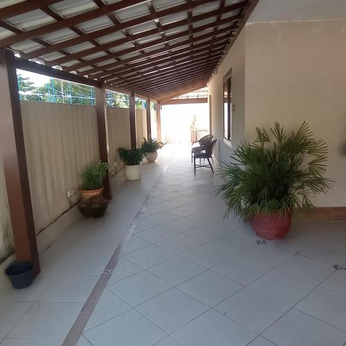 un patio avec des chaises et des plantes en pot dans un bâtiment dans l'établissement Casa de praia, à Salvador