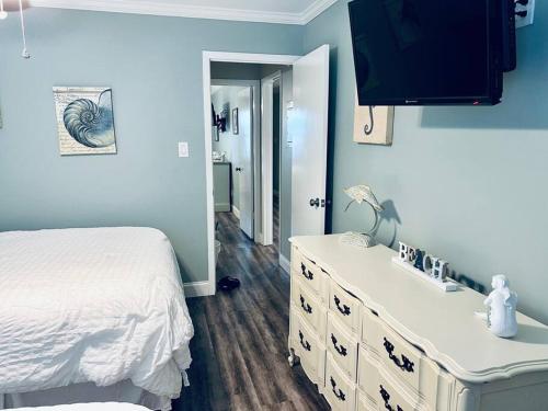 a bedroom with a white bed and a dresser at 2-BDRM Across From Beach 10 min Walk to Hangout! in Gulf Shores