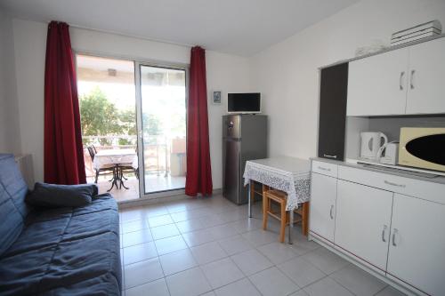 une cuisine et un salon avec un canapé et une table dans l'établissement Studio 4 personnes vue sur la Marina, à Canet