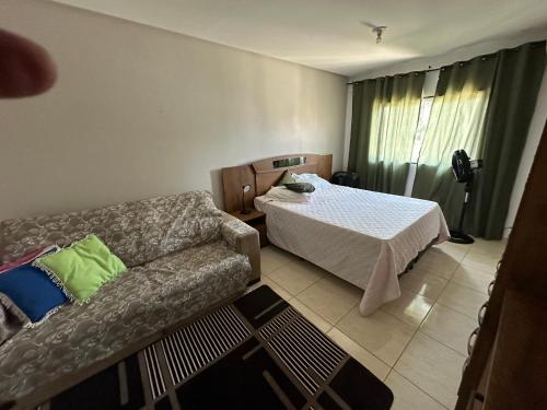 a living room with a bed and a couch at Casa Guarapari - Ferienhaus in Guarapari