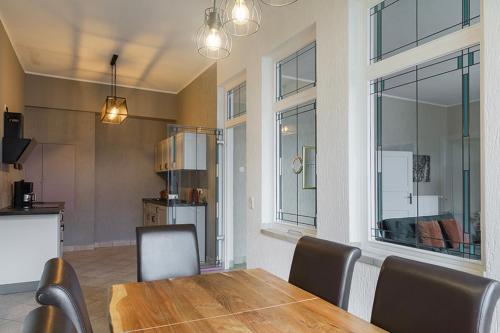 Un comedor con mesa y sillas y una cocina. en Ferienwohnung mit Kamin und traumhafter Dachterrasse mit Weitblick in die Natur, en Neu Gaarz