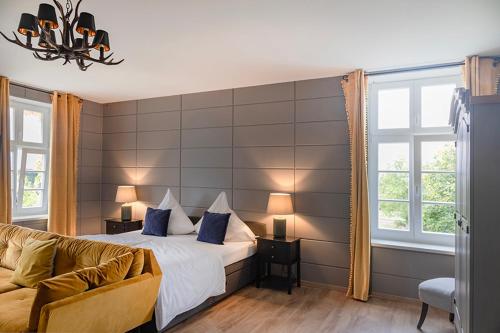 1 dormitorio con cama, sofá y ventanas en Gutshauszimmer Premium, en Neu Gaarz
