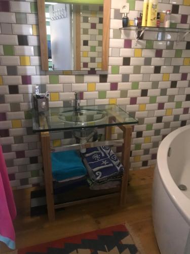 een badkamer met een glazen wastafel en een toilet bij Le grenier in Tauves