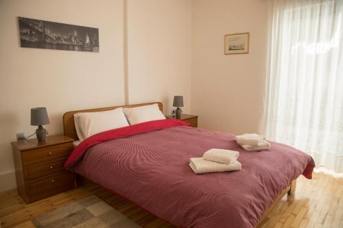 een slaapkamer met een bed met twee handdoeken erop bij Spiri's House-Deluxe Apartment in Kalabaka-Meteora in Kalabaka