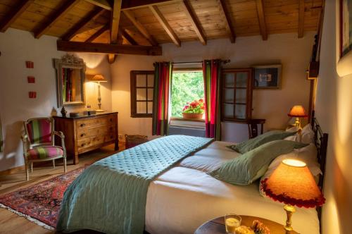 une chambre avec un grand lit et une fenêtre dans l'établissement Le Domaine de Petiosse, à Saint-Julien-en-Born