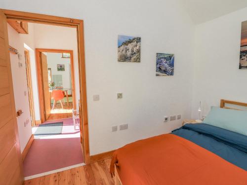 a bedroom with an orange bed and a mirror at Easter Blervie in Forres