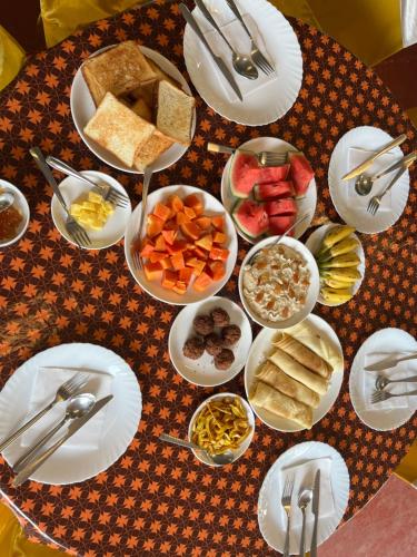 a table with plates and bowls of food on it at Marari Beach Villas in Mararikulam