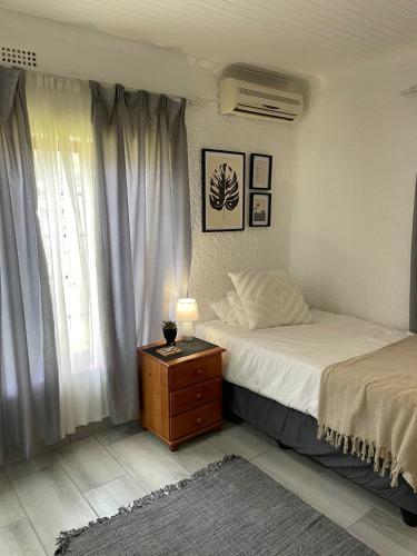 a bedroom with two beds and a table with a lamp at Groenewald's Haven in Nelspruit