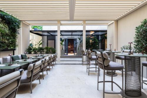 ein Restaurant mit Tischen und Stühlen vor einem Gebäude in der Unterkunft Worldhotel Cristoforo Colombo in Mailand