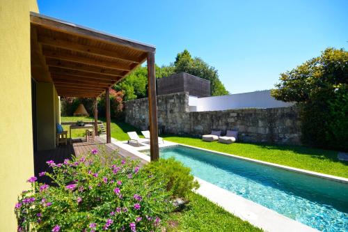 Un patio trasero con piscina y una casa. en Villa 292, en Caminha