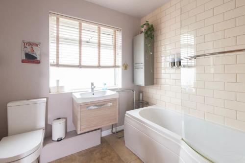 Baño blanco con bañera y lavamanos en Fabulous House in Bath w/parking en Bath