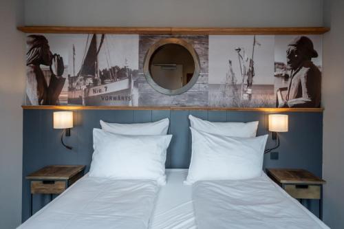 a bedroom with a bed with two pillows and a mirror at 4Hafenzeiten - Ferienwohnung NIE 7 Vorwärts in Timmendorfer Strand