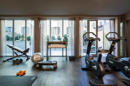 a gym with several exercise equipment in a room with windows at Worldhotel Cristoforo Colombo in Milan