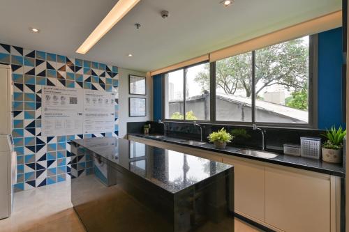 a kitchen with a black counter and blue and white tiles at Studio Prime in Sao Paulo