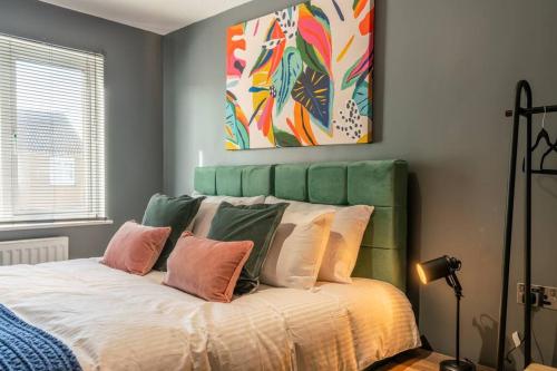 The Perfect Welsh Oasis في نيوبورت: غرفة نوم مع سرير مع اللوح الأمامي والوسائد الخضراء