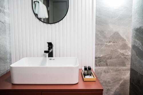 a bathroom with a white sink and a mirror at Hotel Zamca Suceava in Suceava