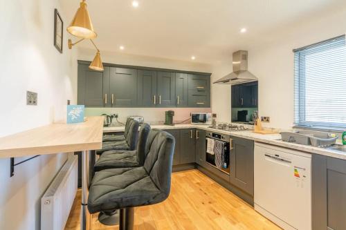a kitchen with gray cabinets and a table and chairs at The Perfect Welsh Oasis in Newport