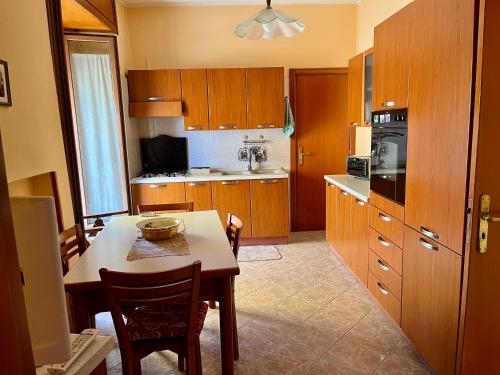 a kitchen with wooden cabinets and a table with chairs at La Panchina sul Corso in Grassano