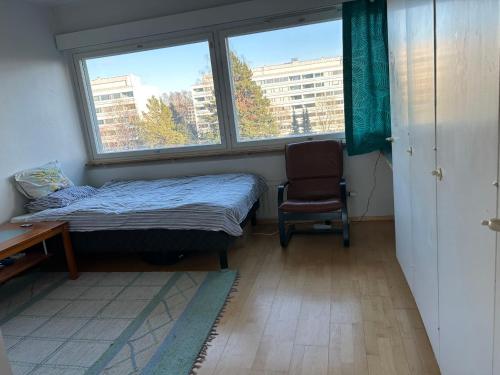 um quarto com uma cama, uma cadeira e uma janela em An entire flat 60m2 with a balcony in Itakeskus of Helsinki em Helsínquia