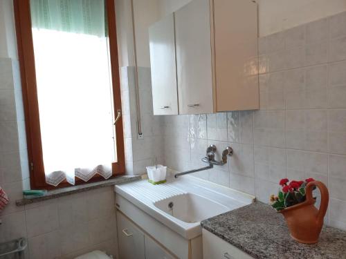 La salle de bains est pourvue d'un lavabo et d'une fenêtre. dans l'établissement Casa di Adele con giardino privato a 150 mt dal mare, à Senigallia