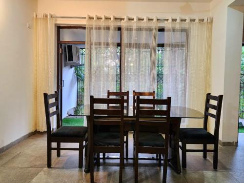 Sal Woods في دهرادون: غرفة طعام مع طاولة وكراسي ونافذة