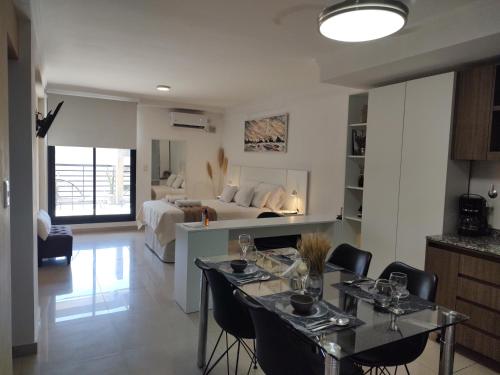 1 dormitorio y sala de estar con mesa de comedor. en Comodo Dpto con Balcon & wifi en Santiago del Estero
