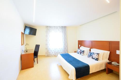 a hotel room with a bed and a desk at Recomeçar Guesthouse in Santa Cruz