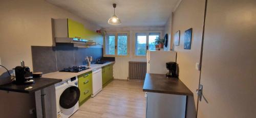 een keuken met een koelkast en een wasmachine bij Gîte du Rocher des Commères in Sirod
