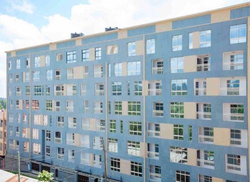 a blue building with many windows in a city at MUCHIE HOMES in Nairobi
