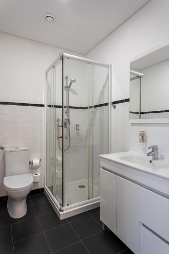 a bathroom with a shower and a toilet and a sink at Guest House A Loja do Cantoneiro in Albergaria-a-Velha
