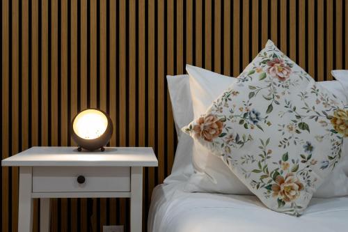 ein Bett mit einem Kissen und einer Lampe auf einem Tisch in der Unterkunft Guest House A Loja do Cantoneiro in Albergaria-a-Velha