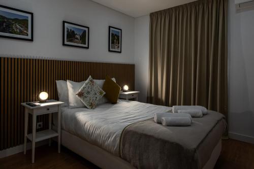 a bedroom with a large bed with two night stands at Guest House A Loja do Cantoneiro in Albergaria-a-Velha